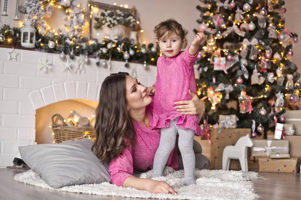 Das Mädchen und seine Mutter liegen auf einer Decke in der Nähe des Weihnachtsmarktes. — Stockfoto