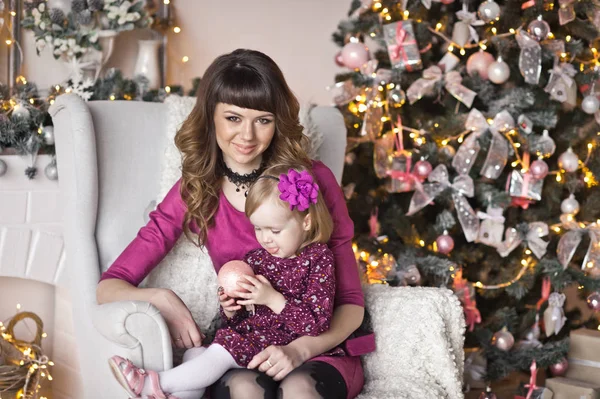 Moeder is dochter knuffelen in de achtergrond van de kerstboom — Stockfoto