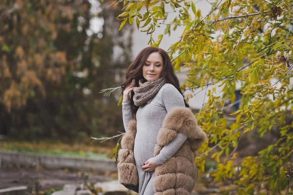 Alegre y feliz madre embarazada caminando en las calles de otoño —  Fotos de Stock