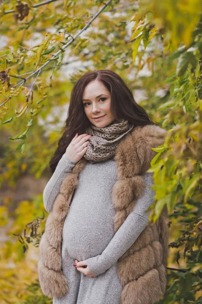 Szczegół portret dziewczyny w ciąży wśród żółknięcie liści — Zdjęcie stockowe