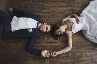 Bir erkek ve bir kadın 6504 elele bir ahşap zemin üzerinde yalan.