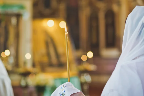 Kerze in der Hand auf dem Hintergrund der Ikonen 6522. — Stockfoto