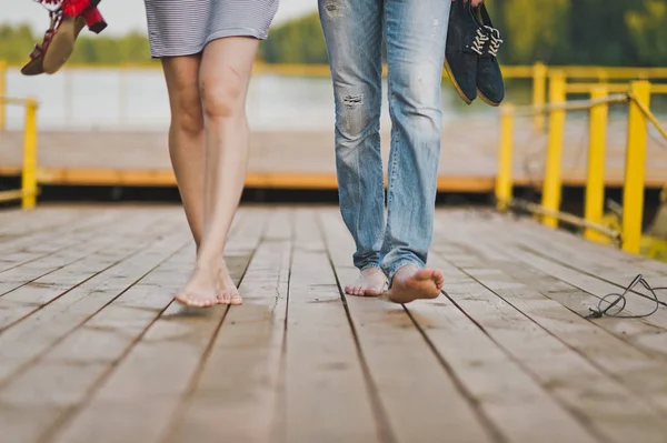 年轻的男人和女孩赤脚走在码头65的木板 — 图库照片