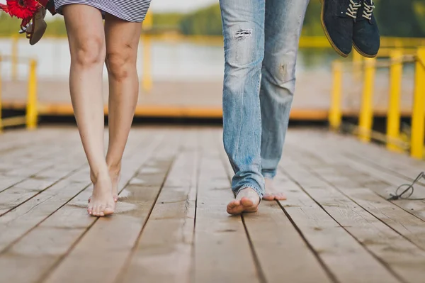 男性和女性赤脚在湖码头的行人天桥 — 图库照片