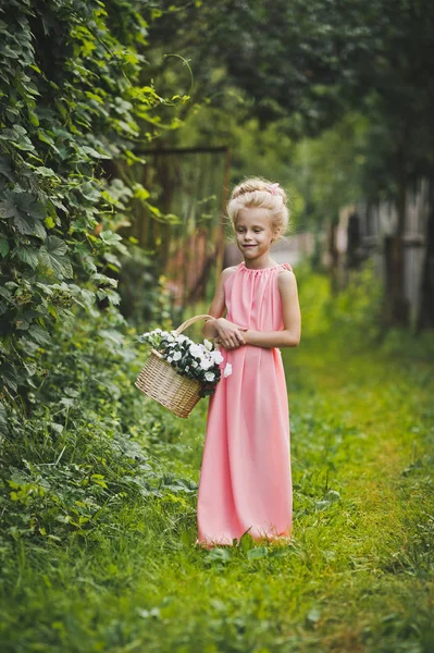 Criança de vestido rosa caminha no jardim 6585 . — Fotografia de Stock