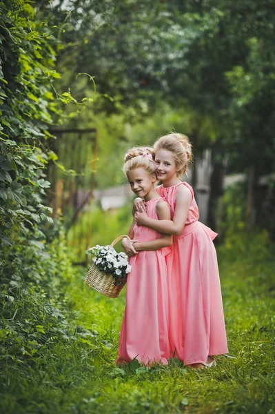 Děti smát a hrát v zahradě mezi zelené křoví — Stock fotografie