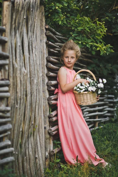 Niño parado en la valla con una cesta de flores 6601 . — Foto de Stock