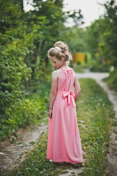 女孩在长的粉红色的礼服摆在自然背景6649. — 图库照片