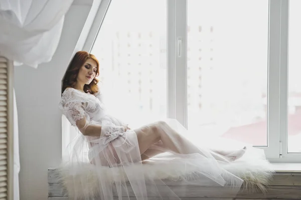 La chica en la posición de sentarse en la ventana de las ventanas — Foto de Stock