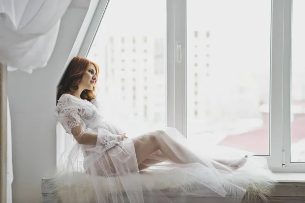 La chica en la posición de sentarse en la ventana de las ventanas — Foto de Stock