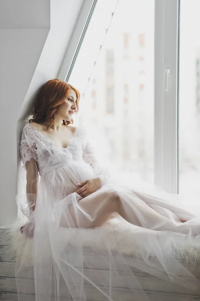 6869 pencere kenarında oturan beyaz bir elbise içinde güzel kız. — Stok fotoğraf
