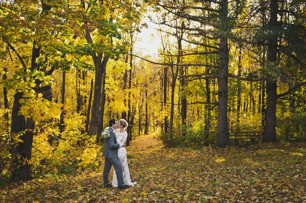 La novia y el novio en un traje moderno para un paseo en un brillante un — Foto de Stock