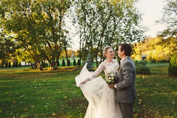 The couple dance around on a green meadow on the background of d — Stock Photo, Image