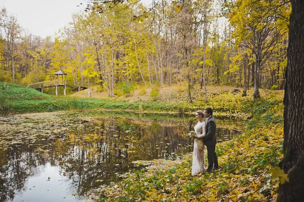 Hermosa pareja joven en el fondo de las hojas de otoño entró th — Foto de Stock