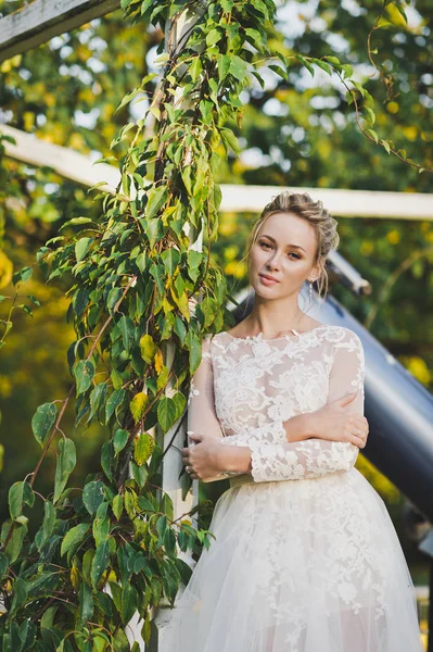 Молодая девушка в элегантном свадебном платье на фоне плюща — стоковое фото
