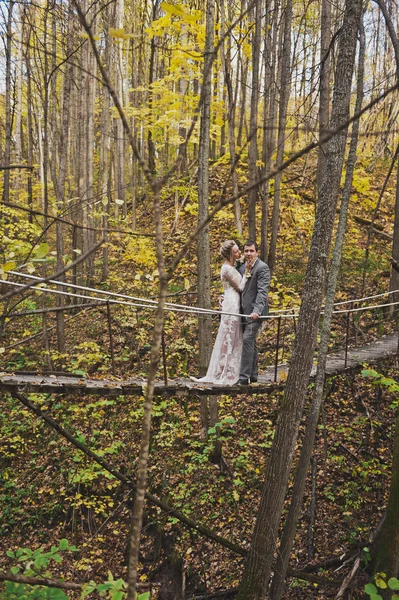 O casal gentilmente abraçar de pé no meio de uma susp instável — Fotografia de Stock