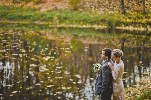 La pareja sueña con el futuro de pie en la orilla de lak caída —  Fotos de Stock