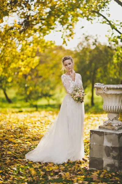 Ritratto della sposa in un abito bianco lungo slinky su sfondo — Foto Stock