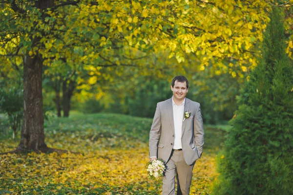 Un jeune homme en costume d'affaires marche dans le jardin 250 . — Photo