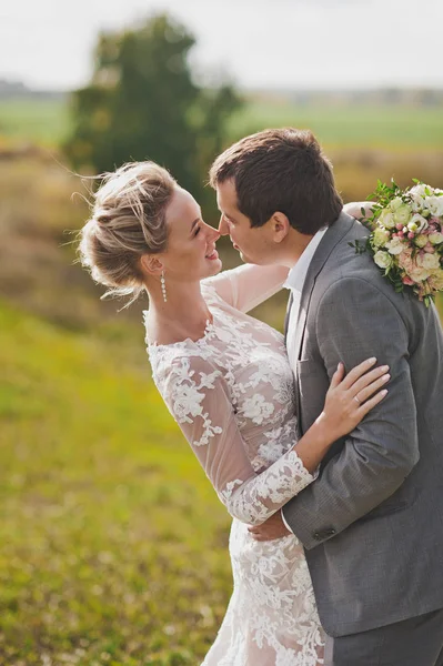 Portret van liefhebbers jonggehuwden op de achtergrond van eindeloze velden — Stockfoto