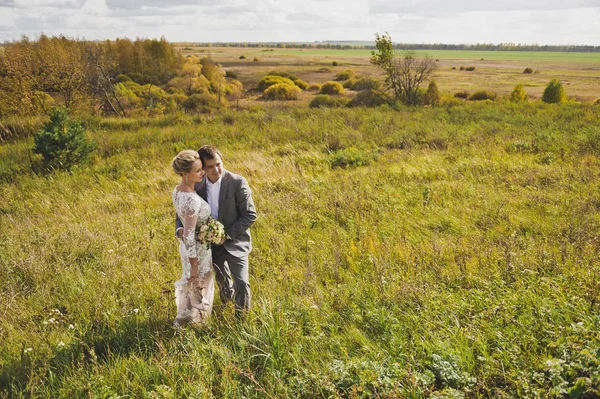 Retrato de los amantes recién casados en el fondo de campos interminables — Foto de Stock