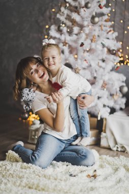 Mutlu anne kızının kollarını arka planda tutan 