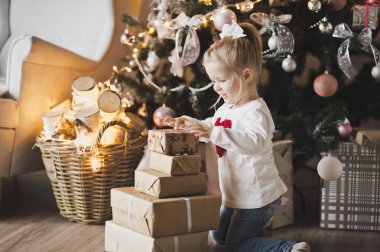 Noel ağacının altında hediyelerle 7249 oturan küçük bir kız.