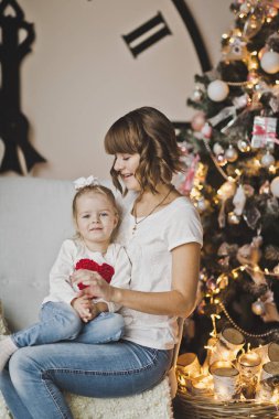 Genç anne ile kızı büyük saatin 7273 kollarını üzerine.
