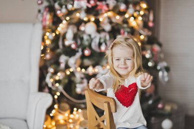 Önde oturan o elbise üzerinde kırmızı bir kalp ile küçük bir kız