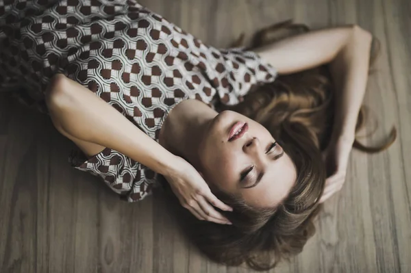 Portrait of a girl with flowing hair lying on the floor 6965. — Stock Photo, Image