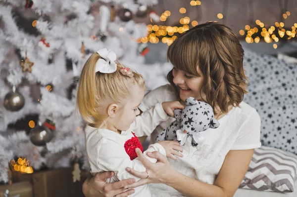 Abraço de família de uma mãe e filha na frente de uma árvore de Natal — Fotografia de Stock