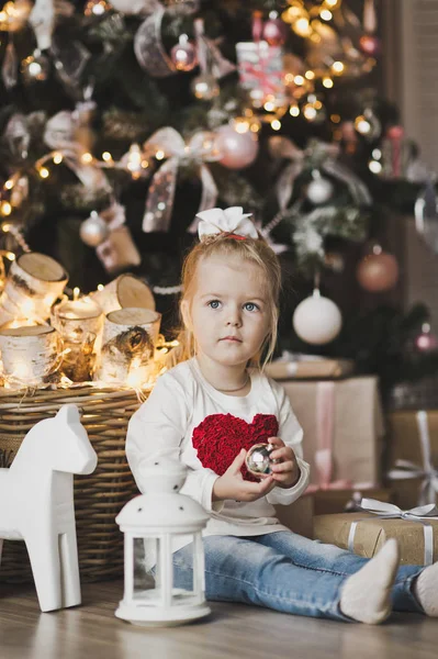 Uma menina sentada sob a árvore de Natal com presentes 7237 . — Fotografia de Stock