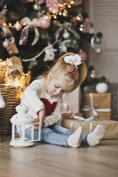 一个小女孩坐在圣诞树下的礼物7236. — 图库照片