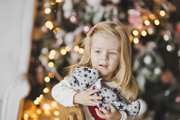 Una niña sentada cerca del árbol de Navidad en espera de una mi — Foto de Stock
