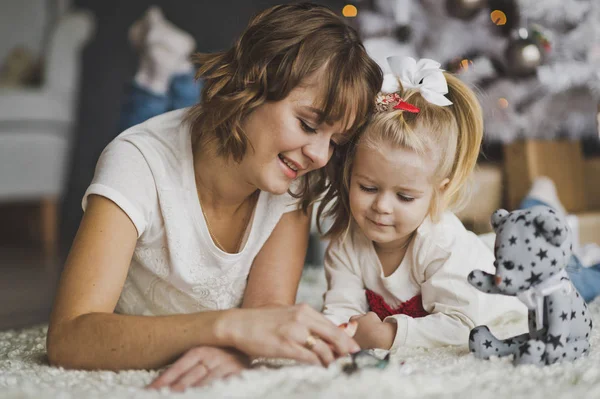 Close-up portrait of mother with daughter playing lying on the f Stock Photo