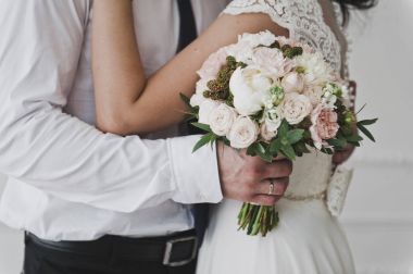 Adam bir buket çiçek 7395 tutan bir womans bel hugs.