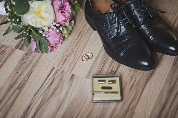 Wedding ring on the floor surrounded by flowers and shoes 7428. — Stock Photo, Image