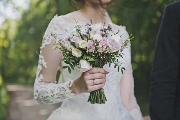 Красивый букет в руках невесты, идущей по — стоковое фото