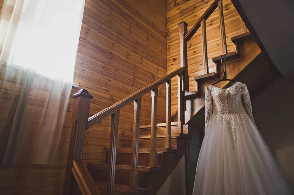 Wedding dress on the steps of a wooden staircase 676. — Stock Photo, Image