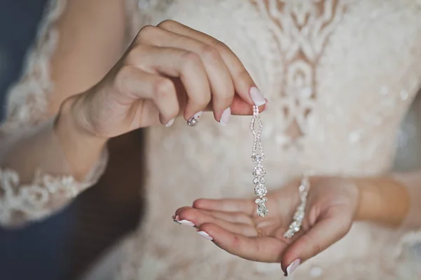 The bride shows off her jewelry before putting 680. — Stock Photo, Image
