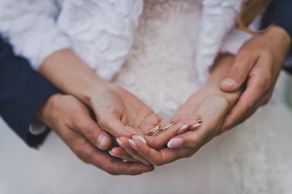 De echtgenoot omarmt de handen van de bruiden met trouwringen 756. — Stockfoto