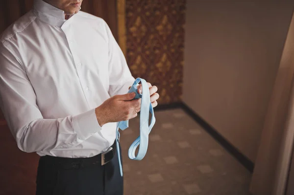 Genç adam bir kravat düğüm 787 bağları. — Stok fotoğraf