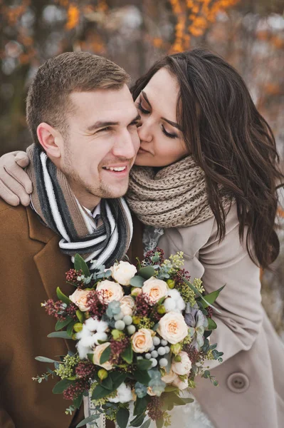 新婚夫妇在冬天的一次微笑中愉快地在浆果间散步 — 图库照片