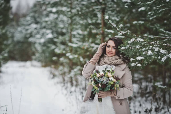 A noiva contra a floresta coberta de neve de inverno de abetos e alfinetes — Fotografia de Stock
