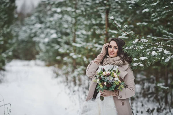 The bride against the winter snow-covered forest of firs and pin — Stock Photo, Image