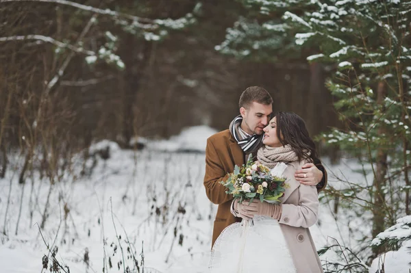 A young couple stands against a snowy pine forest 868. — Stock Photo, Image