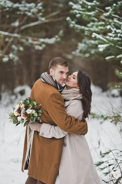 The newlyweds hug each other against the background of the winte — Stock Photo, Image