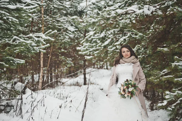 Portrait d'une fille en robe de mariée près de sapins enneigés — Photo