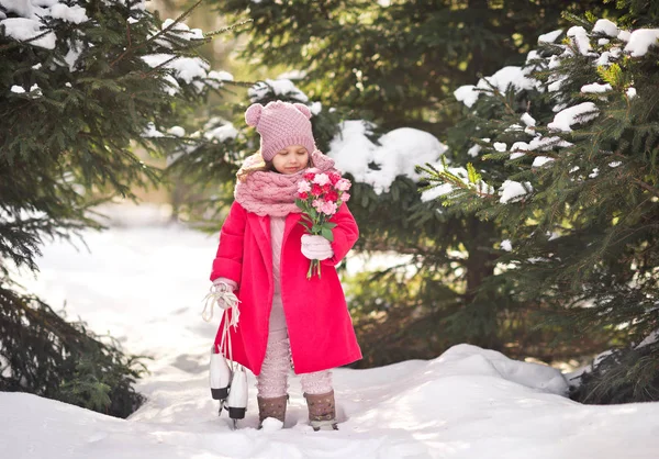 Een klein meisje in een roze jas met een boeket bloemen 917. — Stockfoto