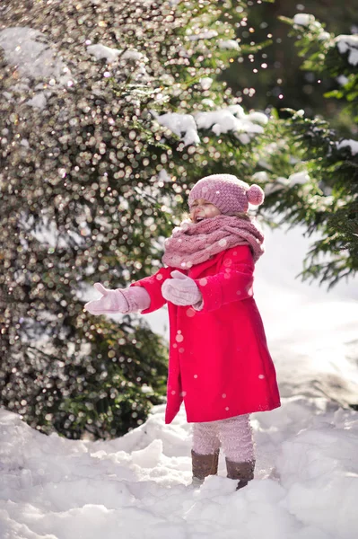 Fröhliches Mädchen fängt Schneeflocken auf, die vom Baum fallen 962. — Stockfoto
